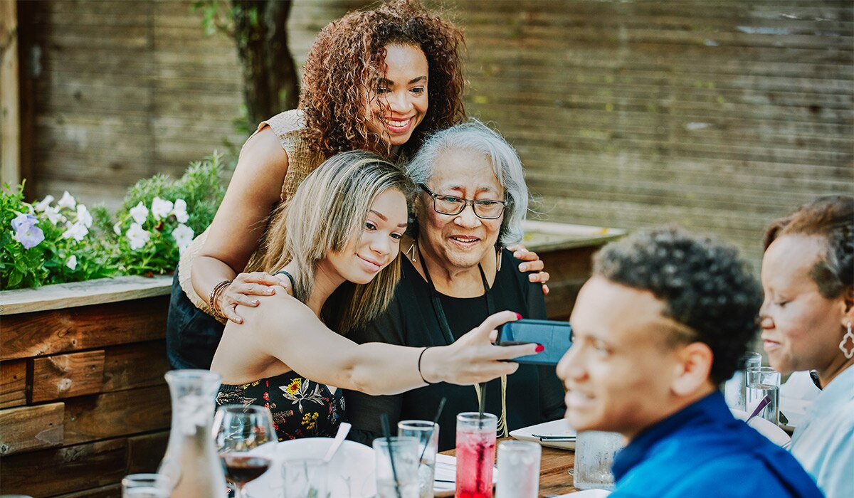 Three generations of women pose for a selfie.